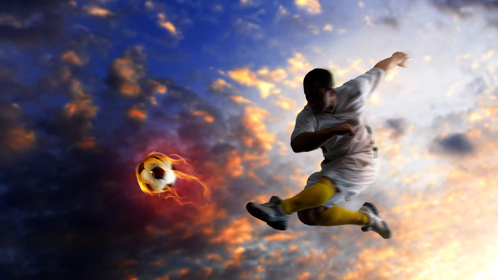 Young soccer player kicking a flaming football