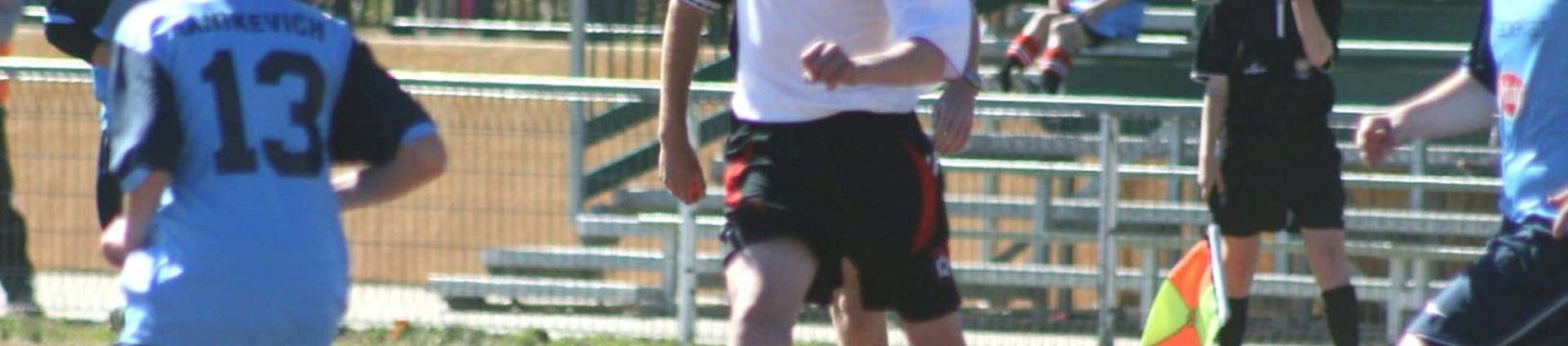 Former student dribbling the ball between defenders