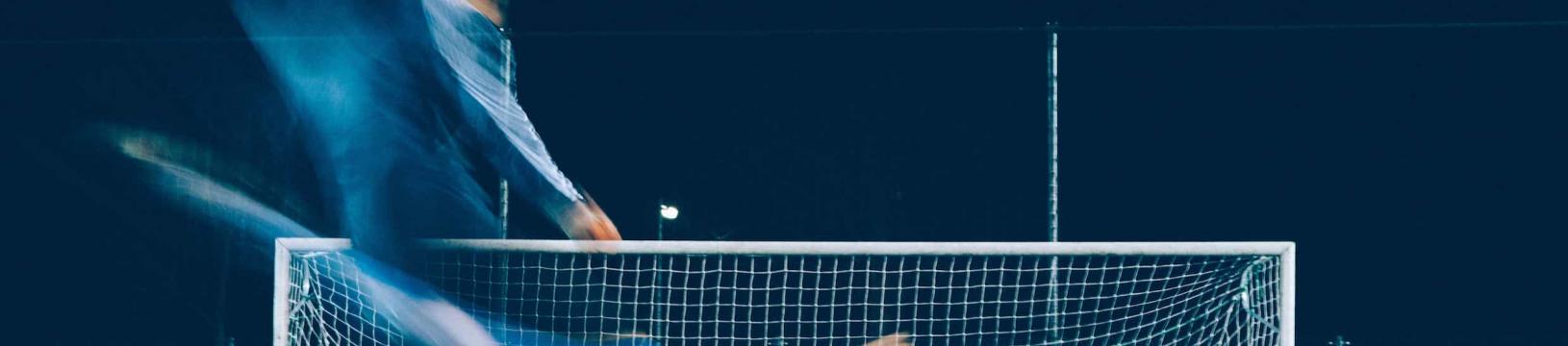 Blurred time lapse image of a striker taking a penalty spot kick