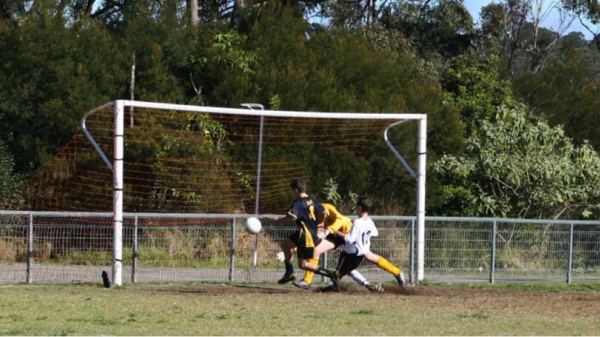 Striker putting the ball past the keeper for a goal